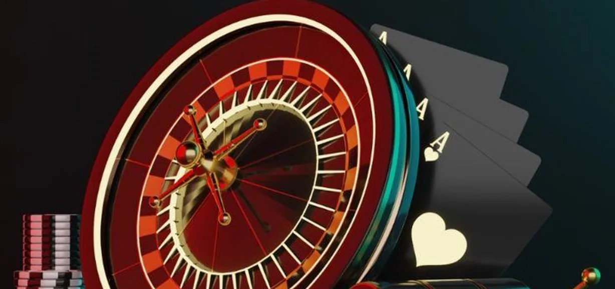A roulette wheel beside a fanned hand of aces and stacked chips
