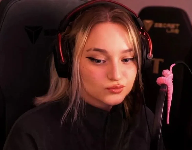 A streamer wearing a gaming headset at her desk